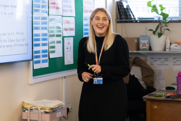 A teacher at a board with a pen in her hand