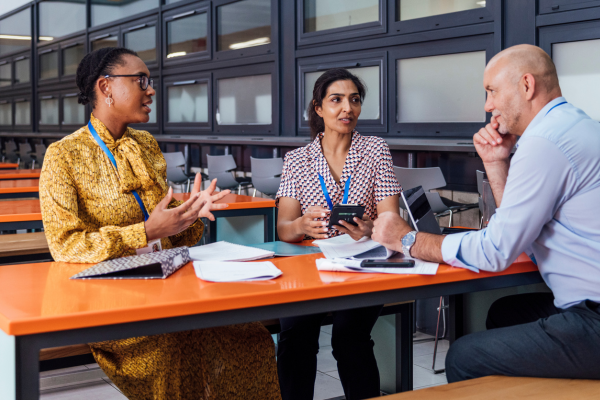 A group of Adults talking sat around a desk